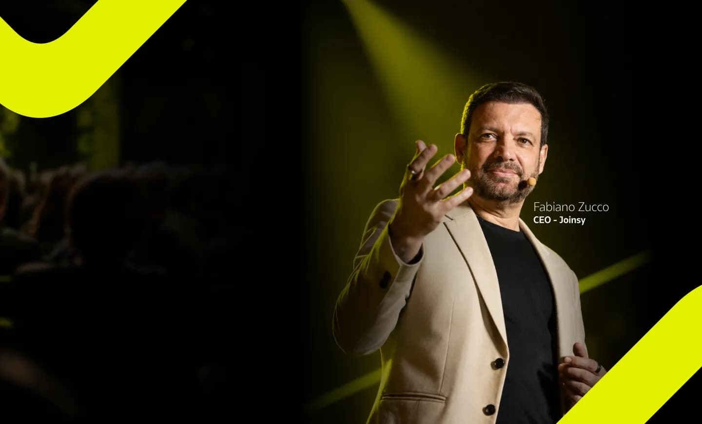 Fabiano Zucco, CEO da Joinsy, durante palestra em um palco iluminado